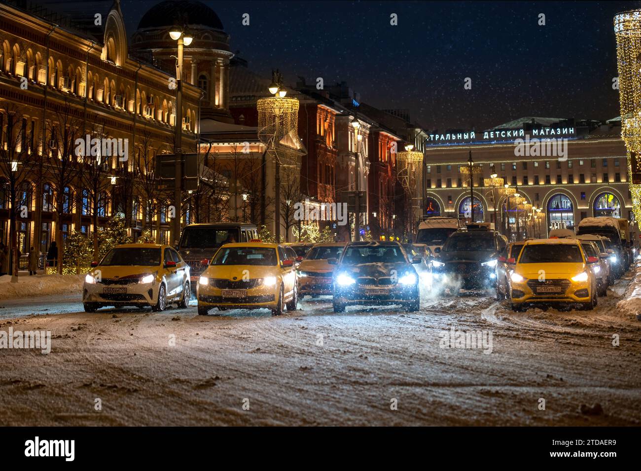 Russland, Moskau, Lubyanka-Platz - 15. dezember 2023. Nachttaxis und PKW-Verkehr auf der Straße, die während des Schneesturms von Schnee bedeckt ist Stockfoto