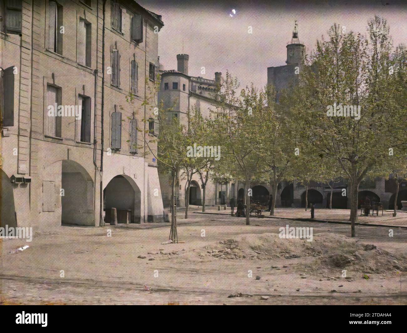 Uzès, Frankreich der Place de la République (heute Place aux Herbes) im Hintergrund der Turm der Kirche Saint-Etienne, Habitat, Architektur, Wohnraum, Straße, District, Arc, Arcade /Arceau, Place, Frankreich, Uzès, Les Arkaden im Hintergrund rechts der Uhrturm und links der Donjon, Uzès, 20.04/1916 - 20.04.1916, Léon, Auguste, Fotograf, 1916 - Provinzen Frankreich - Jean Brunhes, Auguste Léon et Georges Chevalier - (April-Juli), Autochrome, Foto, Glas, Autochrome, Foto, positiv, Horizontal, Format 9 x 12 cm Stockfoto