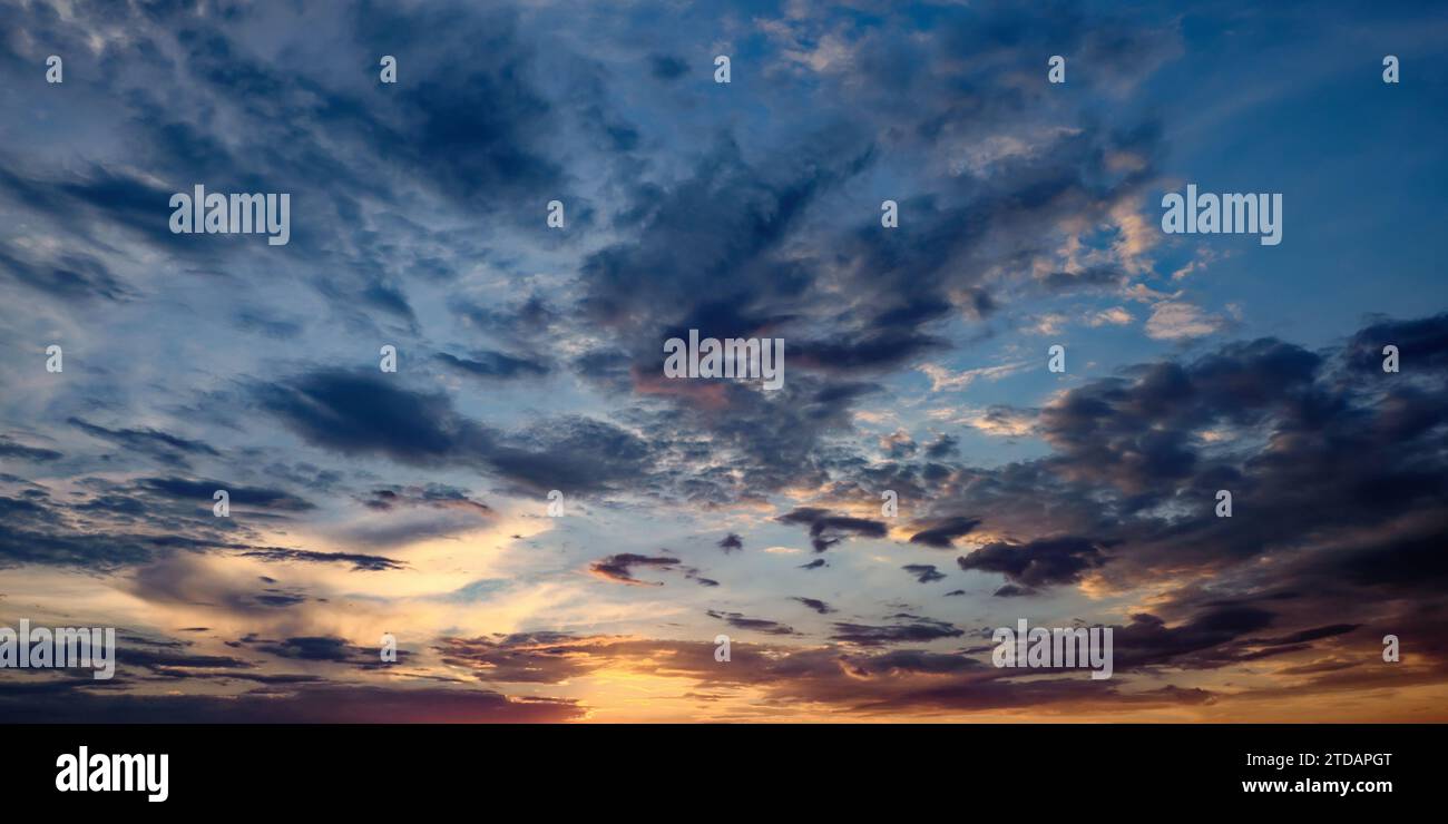 Ein Himmel mit einem rosa und orangen Sonnenuntergang, einem bewölkten Himmel und einem violetten Farbton. Stockfoto