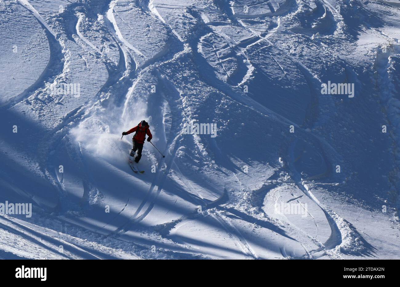 Winterwetter in Bulgarien. Ein Skifahrer fährt eine Skipiste mit Neuschnee hinunter. Stockfoto