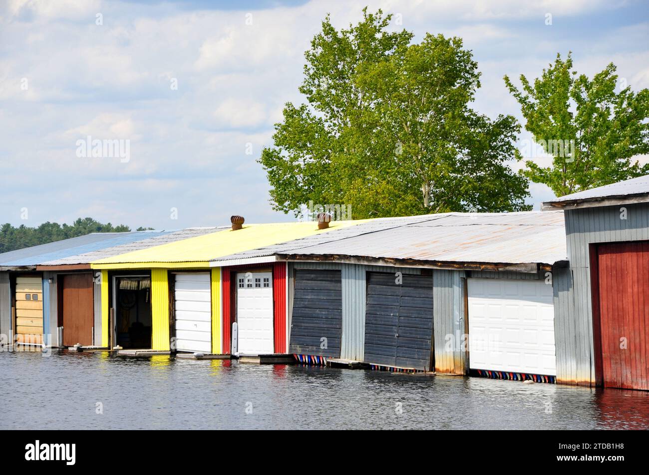 Eine Reihe von farbenfrohen Bootshäusern in Muskoka, Ontario, Kanada, ein beliebter Tagesausflugsort und Cottage Country für viele Einwohner von Toronto. Stockfoto