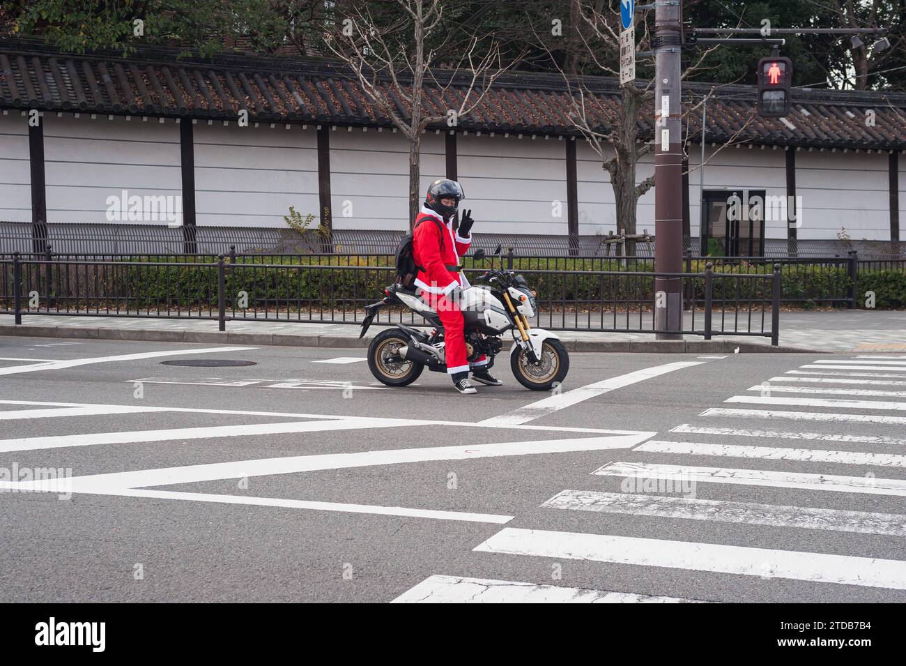 24.12.2017, Kyoto, Japan, Asien - ein Motorradfahrer im Weihnachtsmannkostuem warten an einer Fussgaengerampel. *** 24 12 2017, Kyoto, Japan, Asien Ein als Weihnachtsmann gekleideter Motorradfahrer wartet an einer Fußgängerüberfahrt Stockfoto