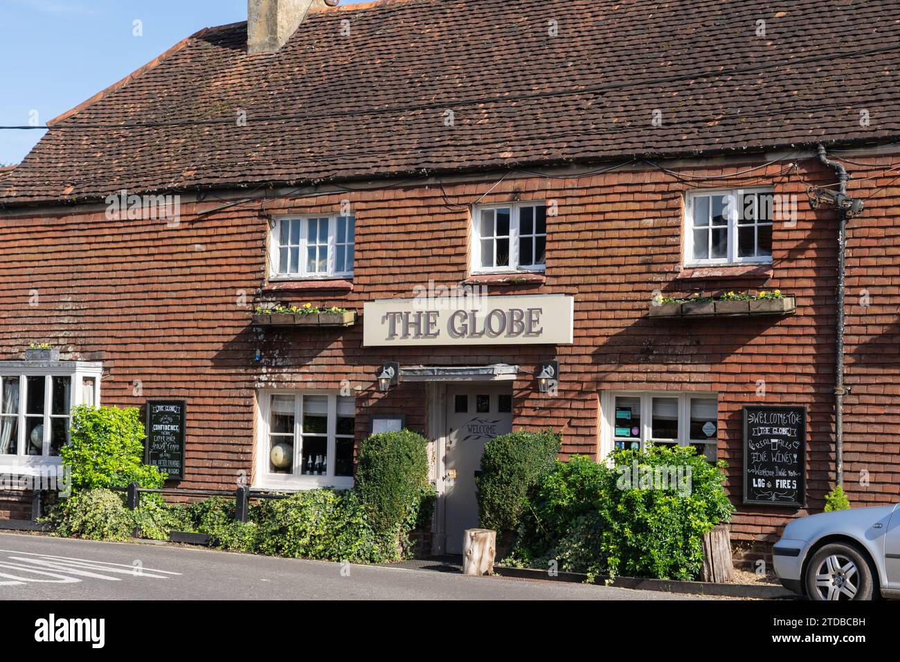 The Front of the Globe: Ein Pub aus dem 15. Jahrhundert mit Garten und Terrasse am Ufer eines kleinen Sees in New Alresford, Hampshire, Großbritannien Stockfoto