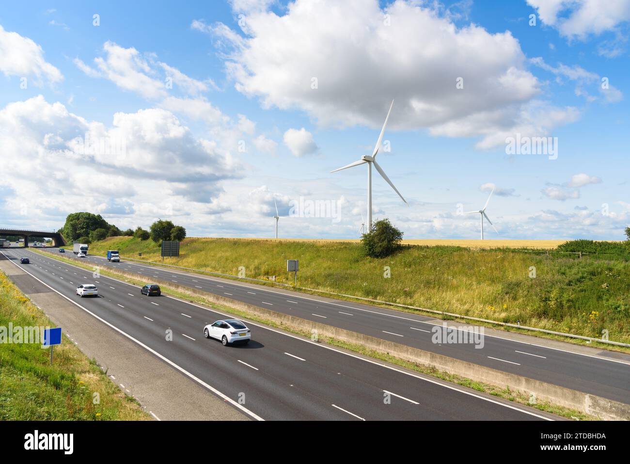 Windpark entlang einer Autobahn in der Landschaft Englands an einem sonnigen Sommertag Stockfoto