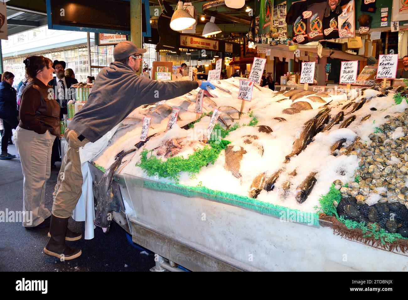 Ein Arbeiter packt frischen Fisch in Eis auf dem Pike Place Market in Seattle Stockfoto