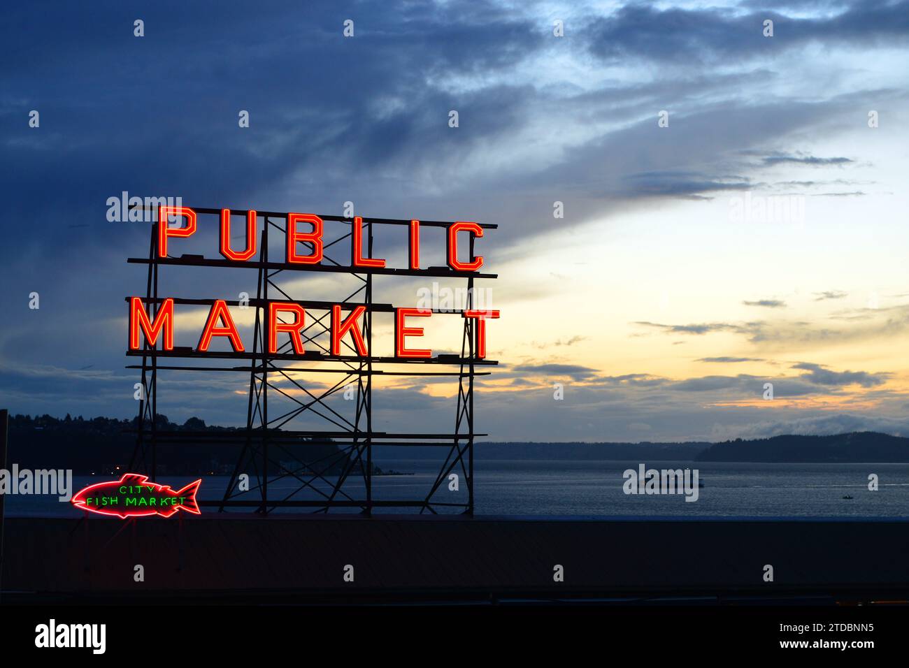 Die Neonlichter des öffentlichen Marktes in Seattle leuchten vor einem Abendhimmel Stockfoto