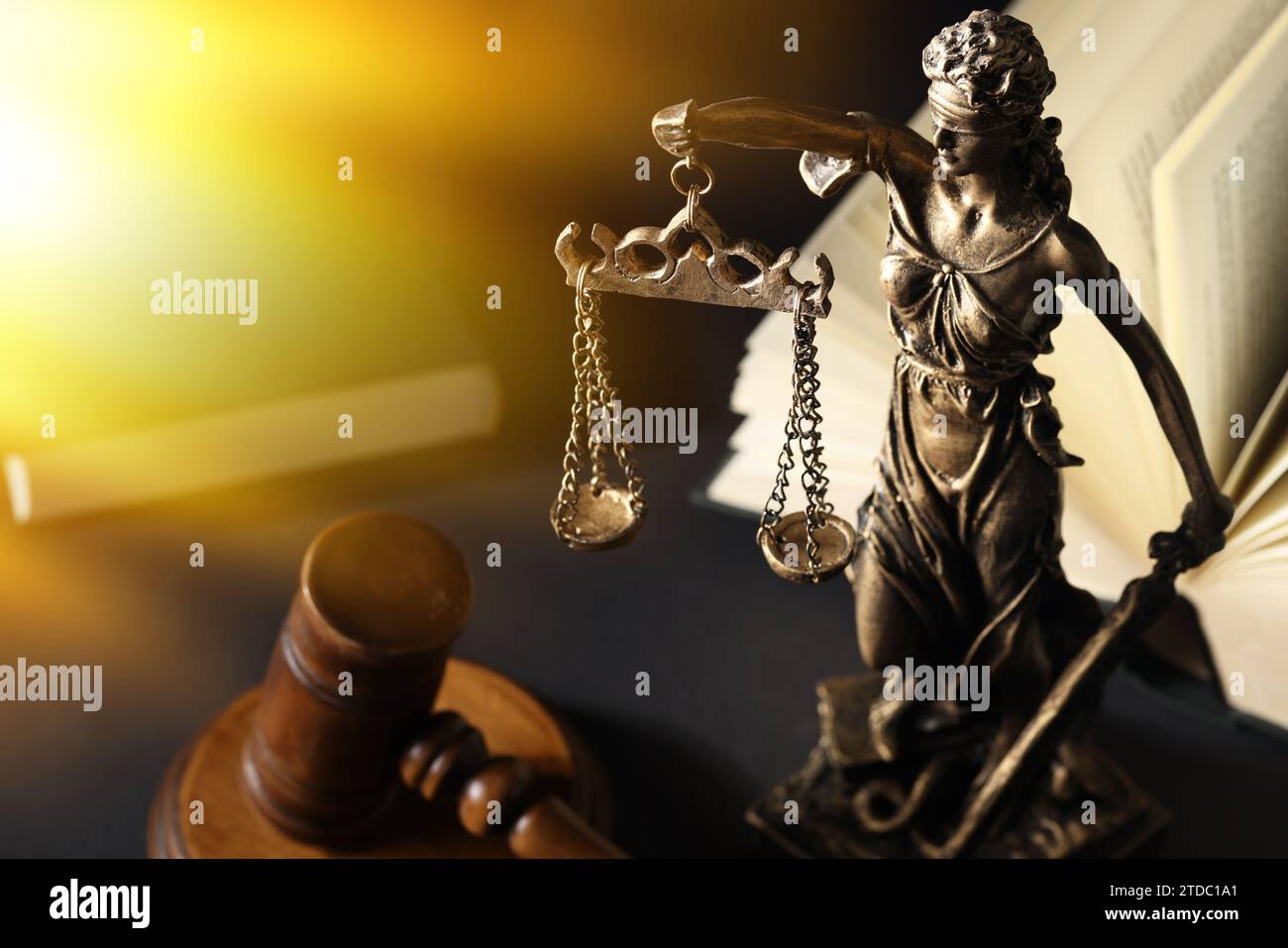 Symbol für eine gerechte Behandlung nach dem Gesetz. Statue von Lady Justice, Hammer und Buch auf schwarzem Tisch, Platz für Text Stockfoto