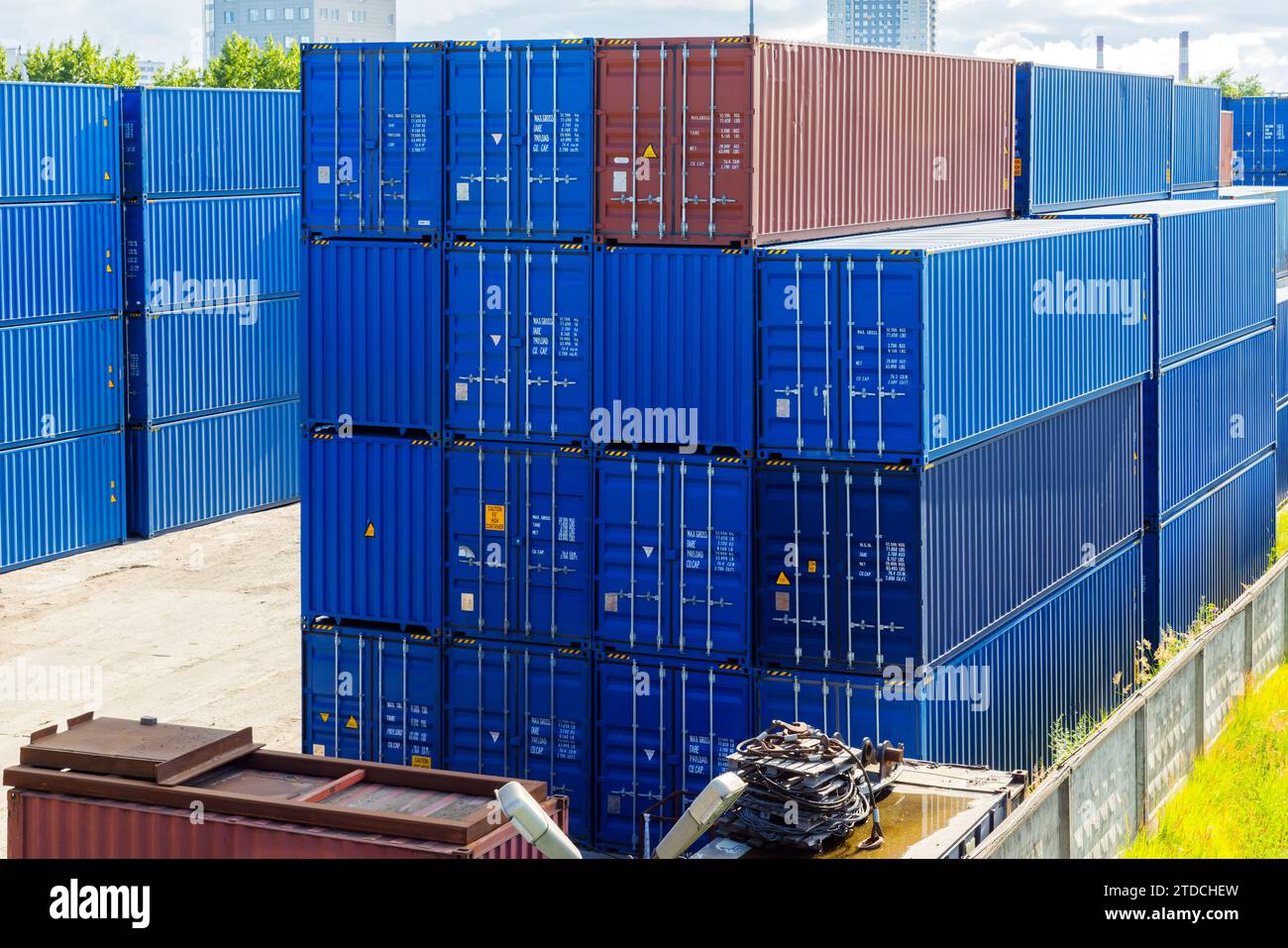 Blaue Frachtcontainer stapeln sich an sonnigen Tagen im Lagerbereich Stockfoto