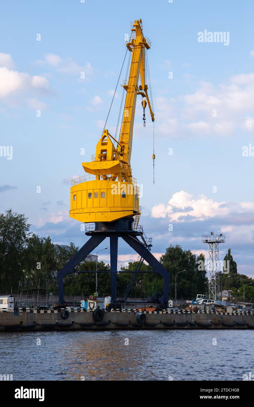 Gelber Portalkran auf blauem Sockel steht im Hafen von Kaliningrad, Russland. Vertikales Foto Stockfoto