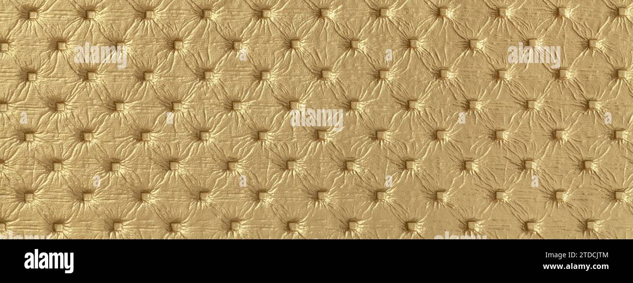 Textur aus goldenem Leder Hintergrund mit Großbuchstaben Muster, Makro. Gelbes Textil im Retro-Chesterfield-Stil. Vintage-Stoff im Hintergrund. Stockfoto