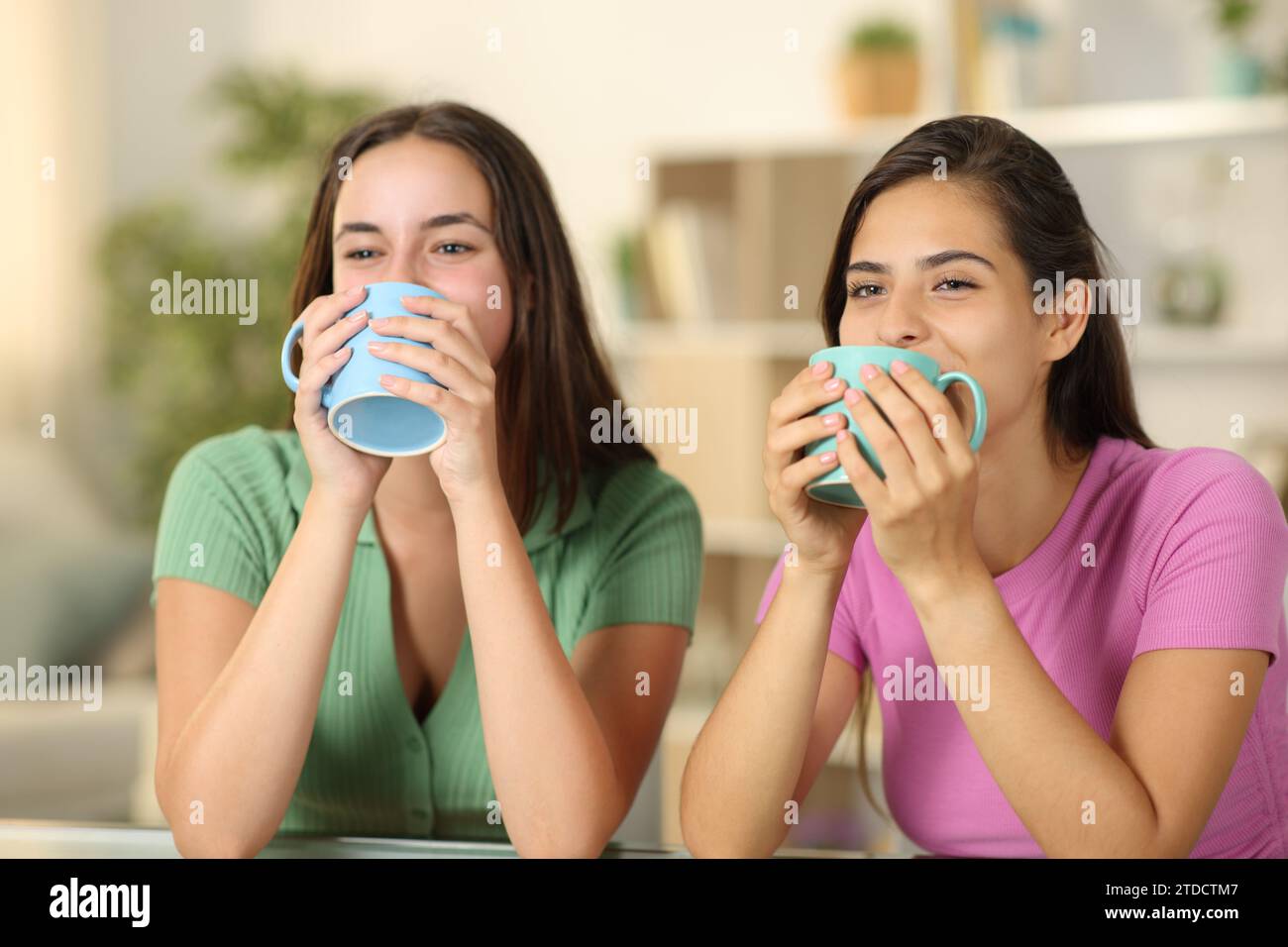 Zwei lustige Frauen trinken zu Hause Kaffee Stockfoto