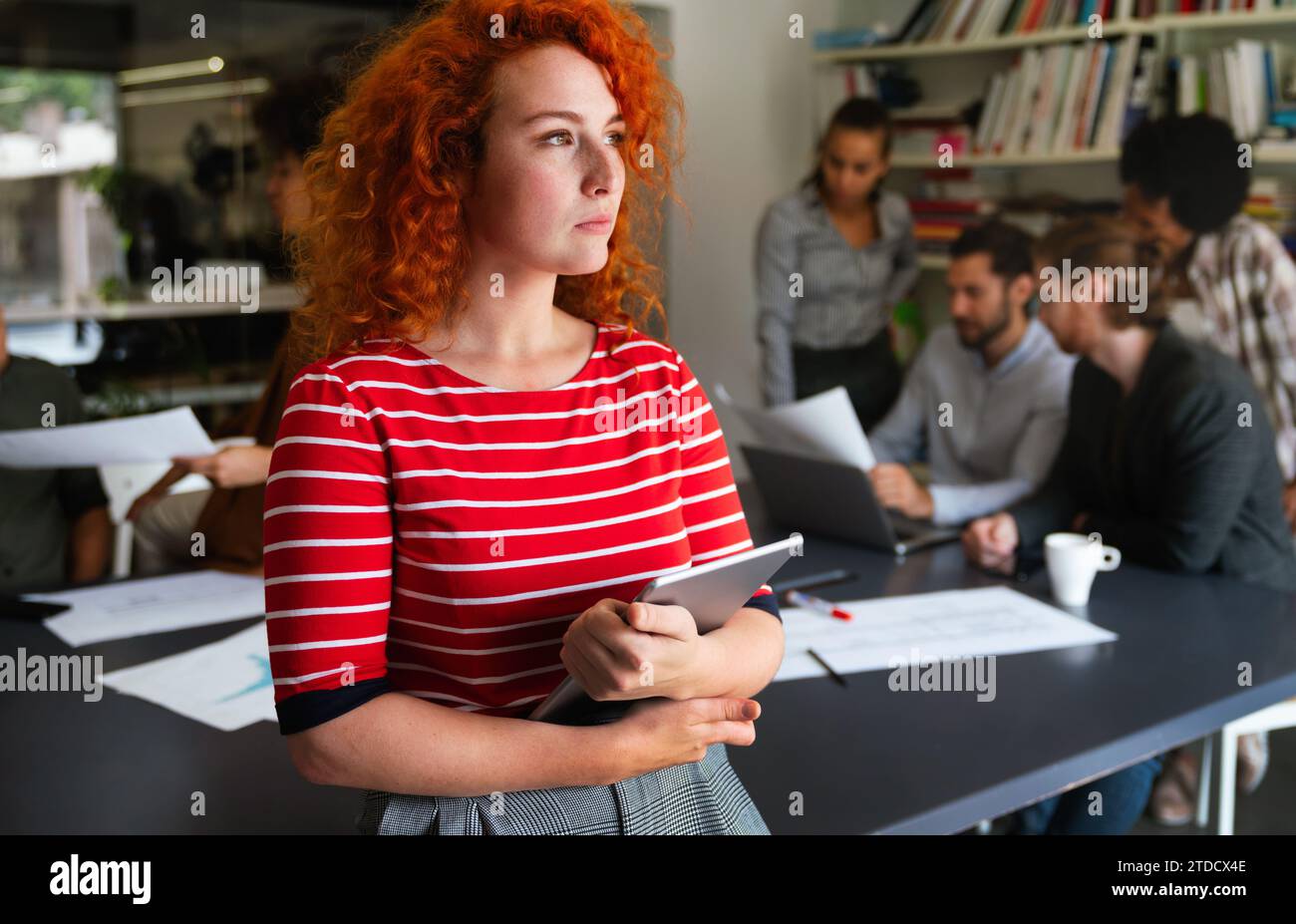 Porträt einer jungen glücklichen Erfolgsfrau, die an einem modernen Arbeitsplatz arbeitet, Startup-Mitarbeiter-Konzept Stockfoto
