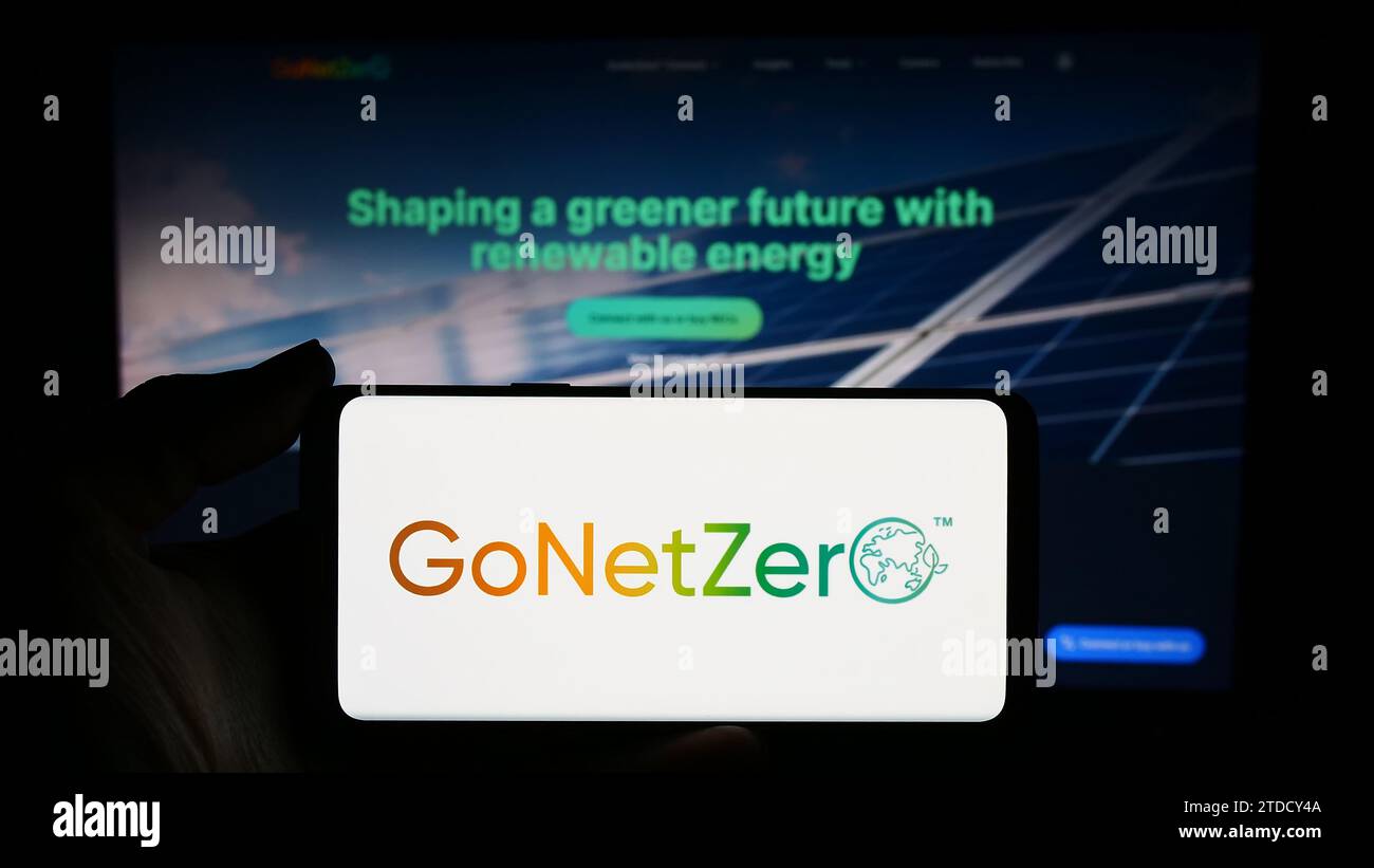 Person, die ein Smartphone mit dem Logo des singapurischen CO2-Management-Unternehmens GoNetZero vor der Website hält. Schwerpunkt auf dem Display des Telefons. Stockfoto