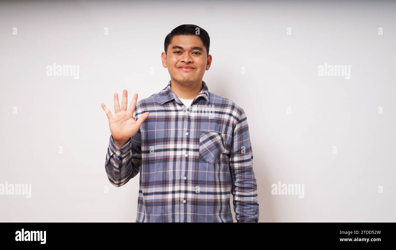 Junger asiatischer Mann mit glücklichem Gesichtsausdruck und fünf Fingern Zeichen Stockfoto