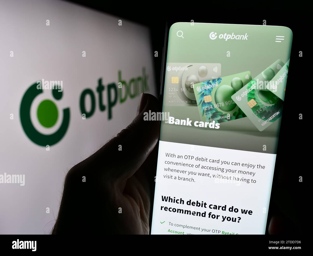 Person, die ein Mobiltelefon hält, mit der Webseite des ungarischen Finanzdienstleisters OTP Bank Group vor dem Logo. Konzentrieren Sie sich auf die Mitte des Telefondisplays. Stockfoto