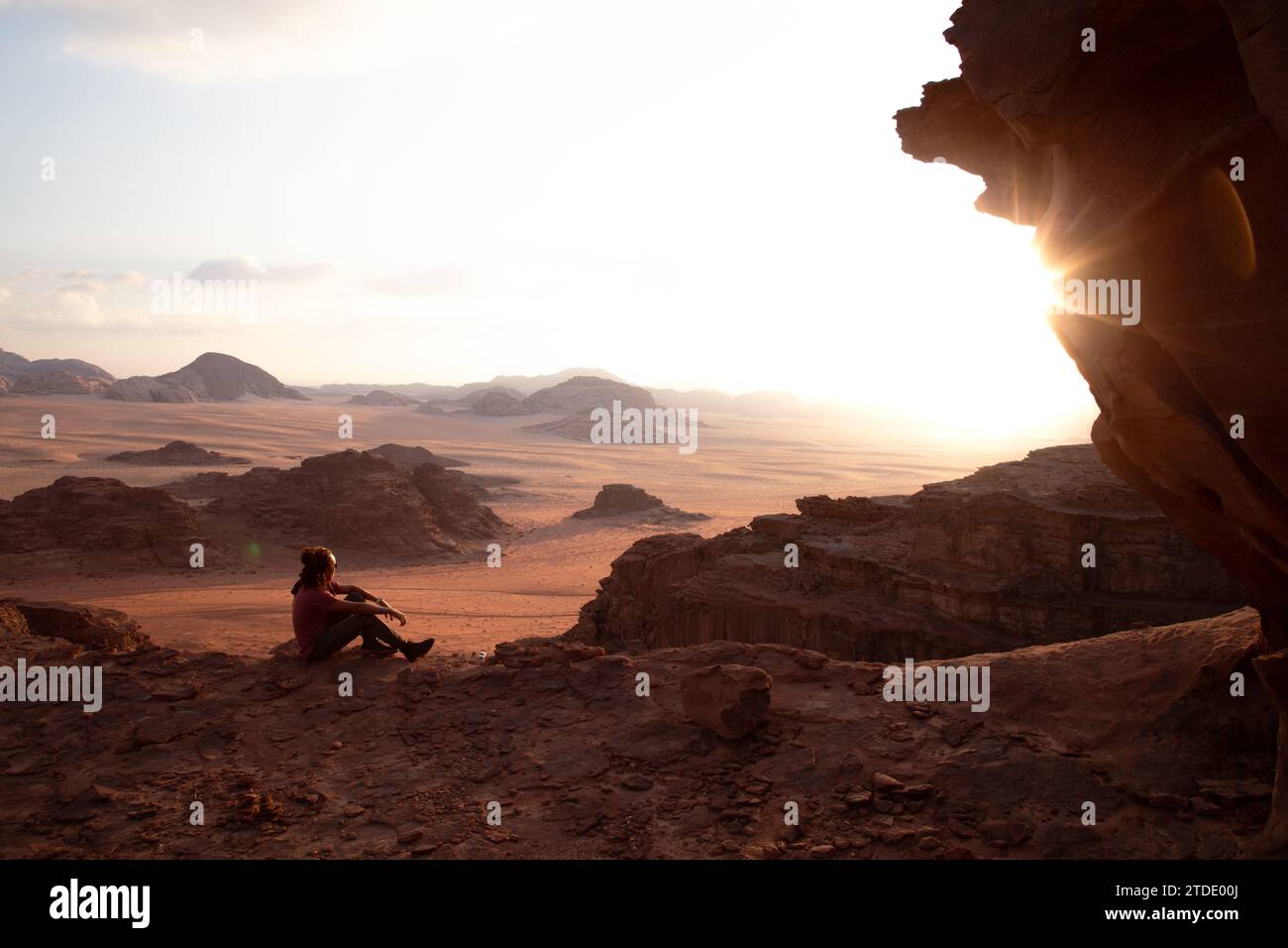 Ein Mann, der während des Sonnenuntergangs in Wadi Rum auf die Wüste blickt Stockfoto