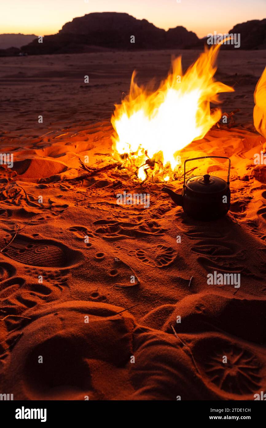 Teekanne neben der Feuerstelle, umgeben von rotem Wüstensand, Jordanien Stockfoto