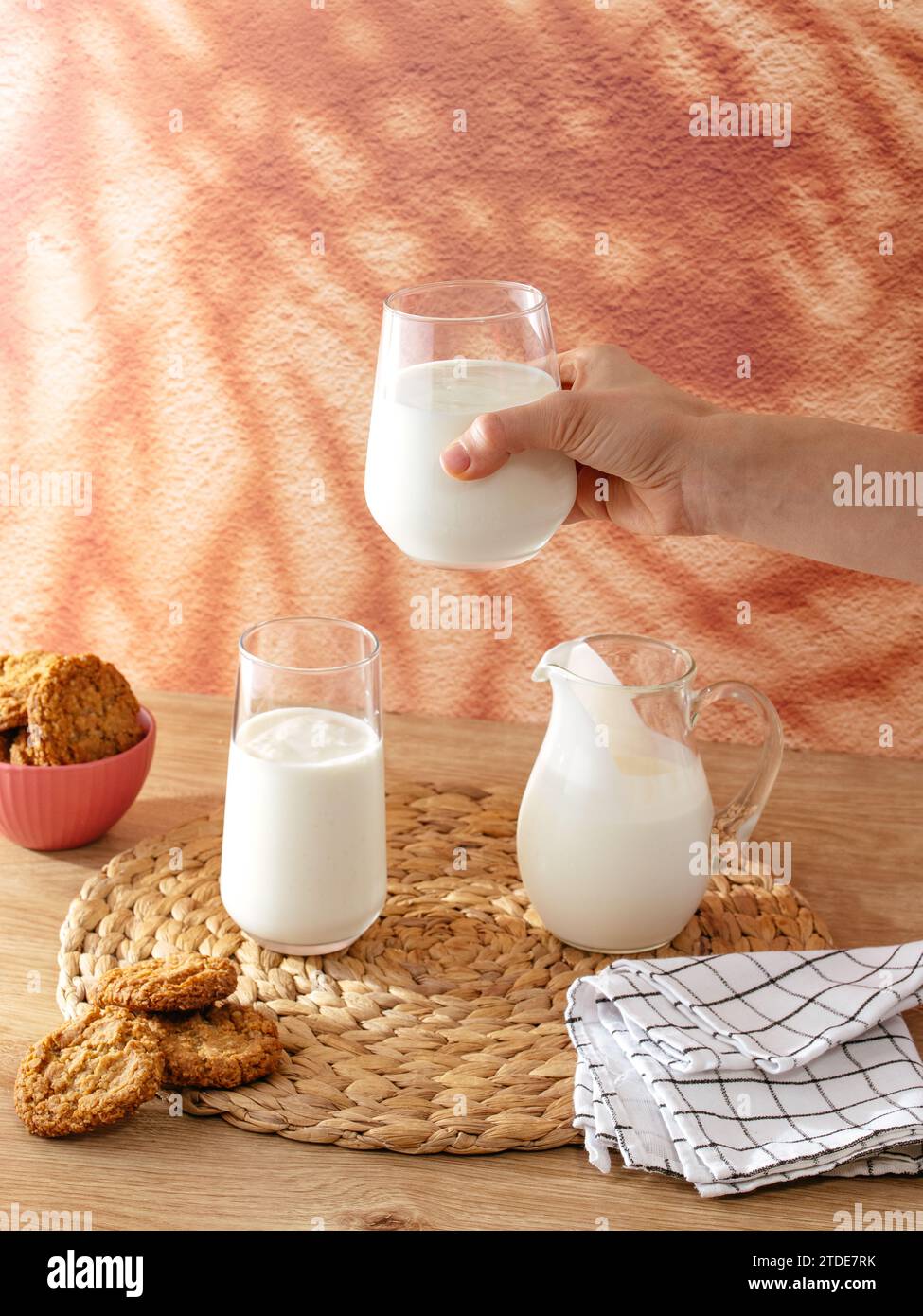 Die Hand einer Frau hält ein Glas Milch Stockfoto