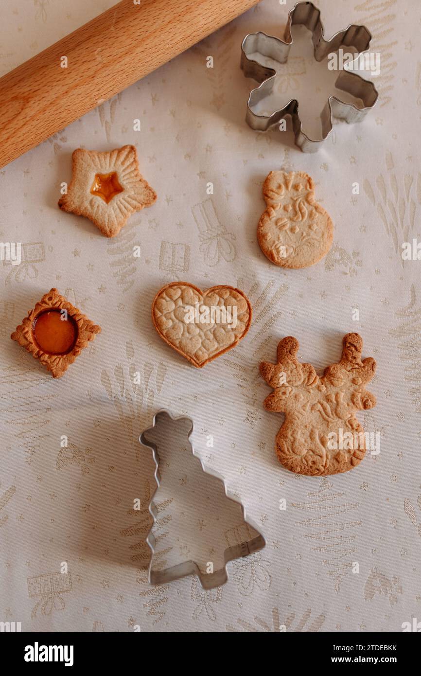weihnachtskekse und -Ausstecher auf einer gemütlichen Tischdecke Stockfoto