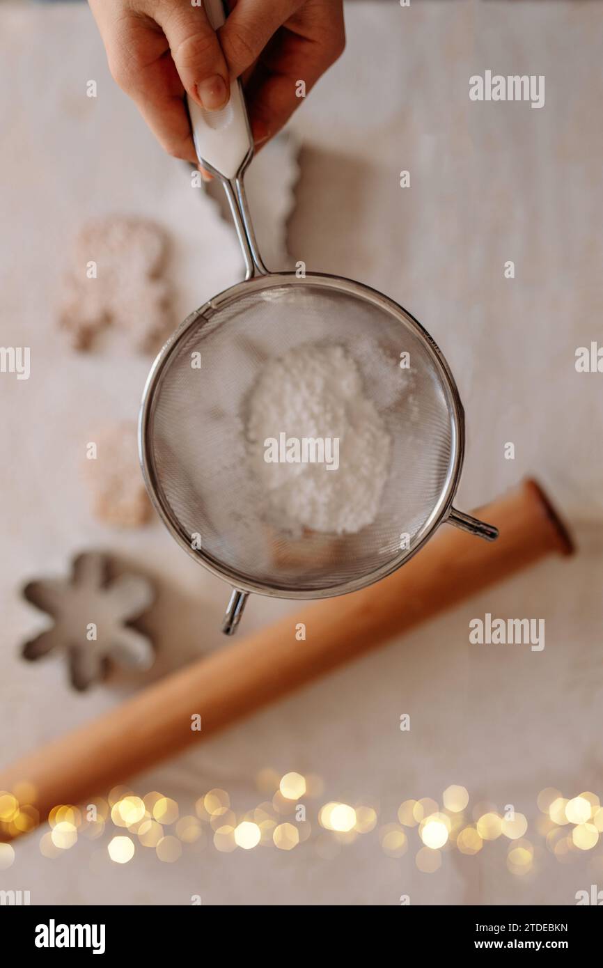 Zucker auf weihnachtskekse streuen Stockfoto