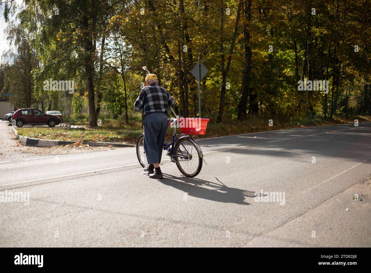 Ein Mann überquert die Straße mit einem Fahrrad. Stockfoto