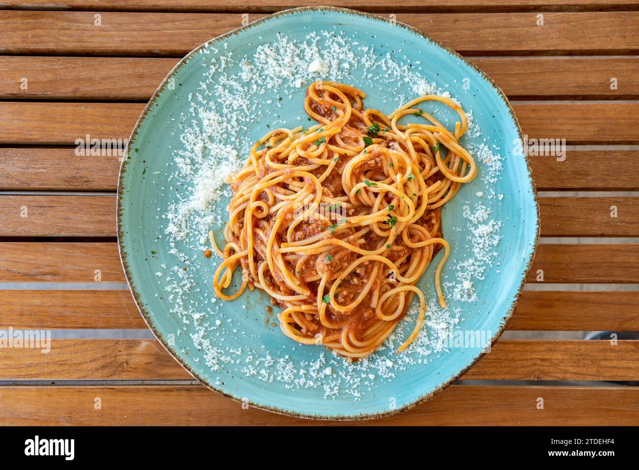 Ein Blick aus der Vogelperspektive über einen Teller mit frischen italienischen Spaghetti Bolognese auf einem Holztisch Stockfoto