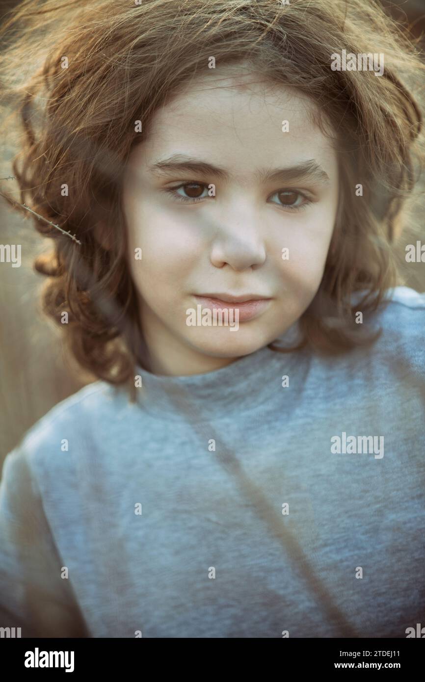 Hübscher Junge mit langen Haaren draußen Stockfoto