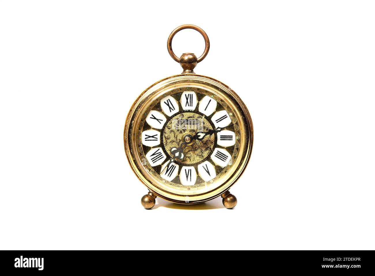 Ein alter goldener analoger Wecker mit mechanischem Uhrwerk isoliert auf weißem Hintergrund Stockfoto
