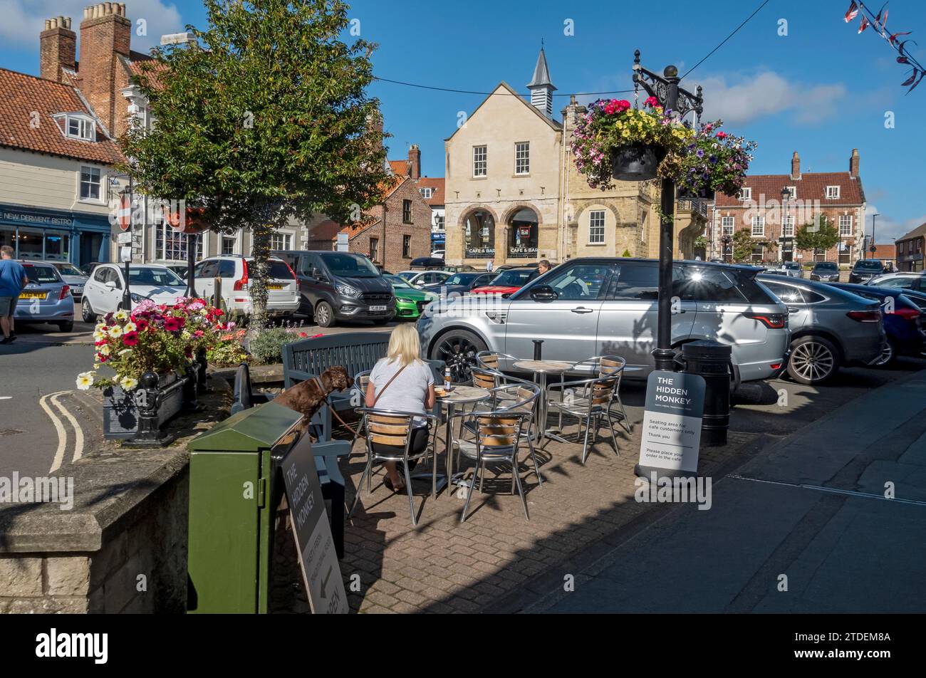 Das alte Rathaus und Parkplätze für Autos und Straßencafe Marktplatz im Freien im Sommer Malton North Yorkshire England Großbritannien Stockfoto