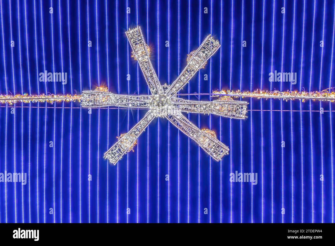 Detail eines Kronleuchters, der an einer blauen Decke aus Weihnachtslichtern hängt, als Dekoration im Rathaus von Sevilla, um die Kathedrale herum, bei christmas tim Stockfoto