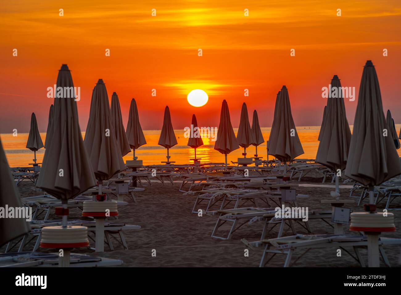 Blick auf Sonnenaufgang und Sonnenschirme am Lido am Strand von Rimini, Rimini, Emilia-Romagna, Italien, Europa Stockfoto