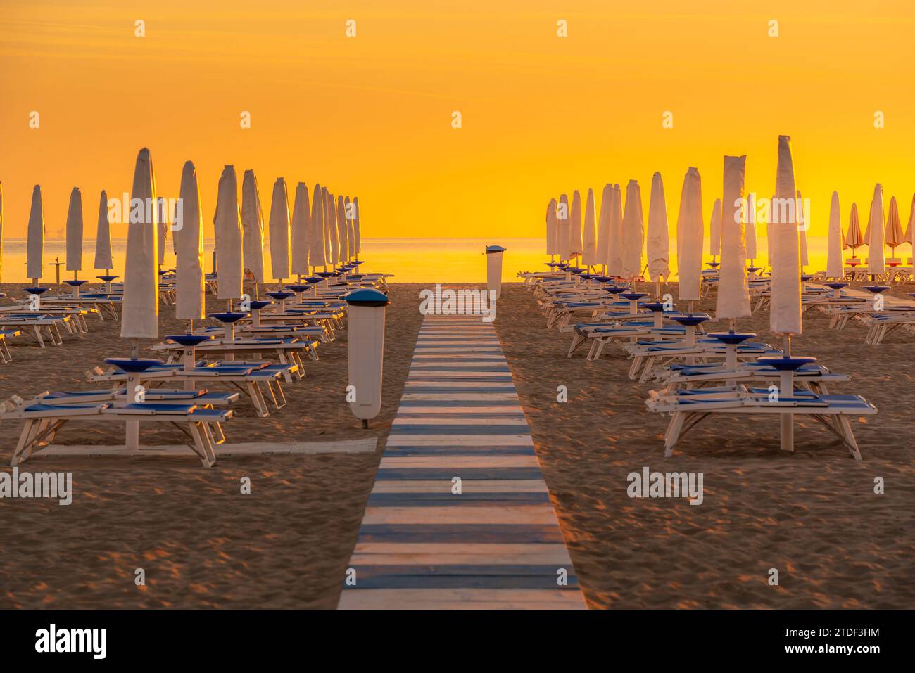 Blick auf Sonnenaufgang und Sonnenschirme am Lido am Strand von Rimini, Rimini, Emilia-Romagna, Italien, Europa Stockfoto