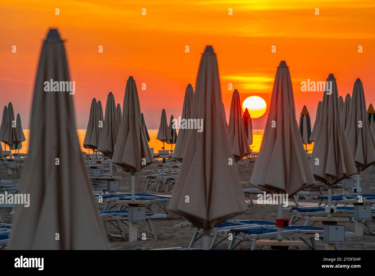 Blick auf Sonnenaufgang und Sonnenschirme am Lido am Strand von Rimini, Rimini, Emilia-Romagna, Italien, Europa Stockfoto