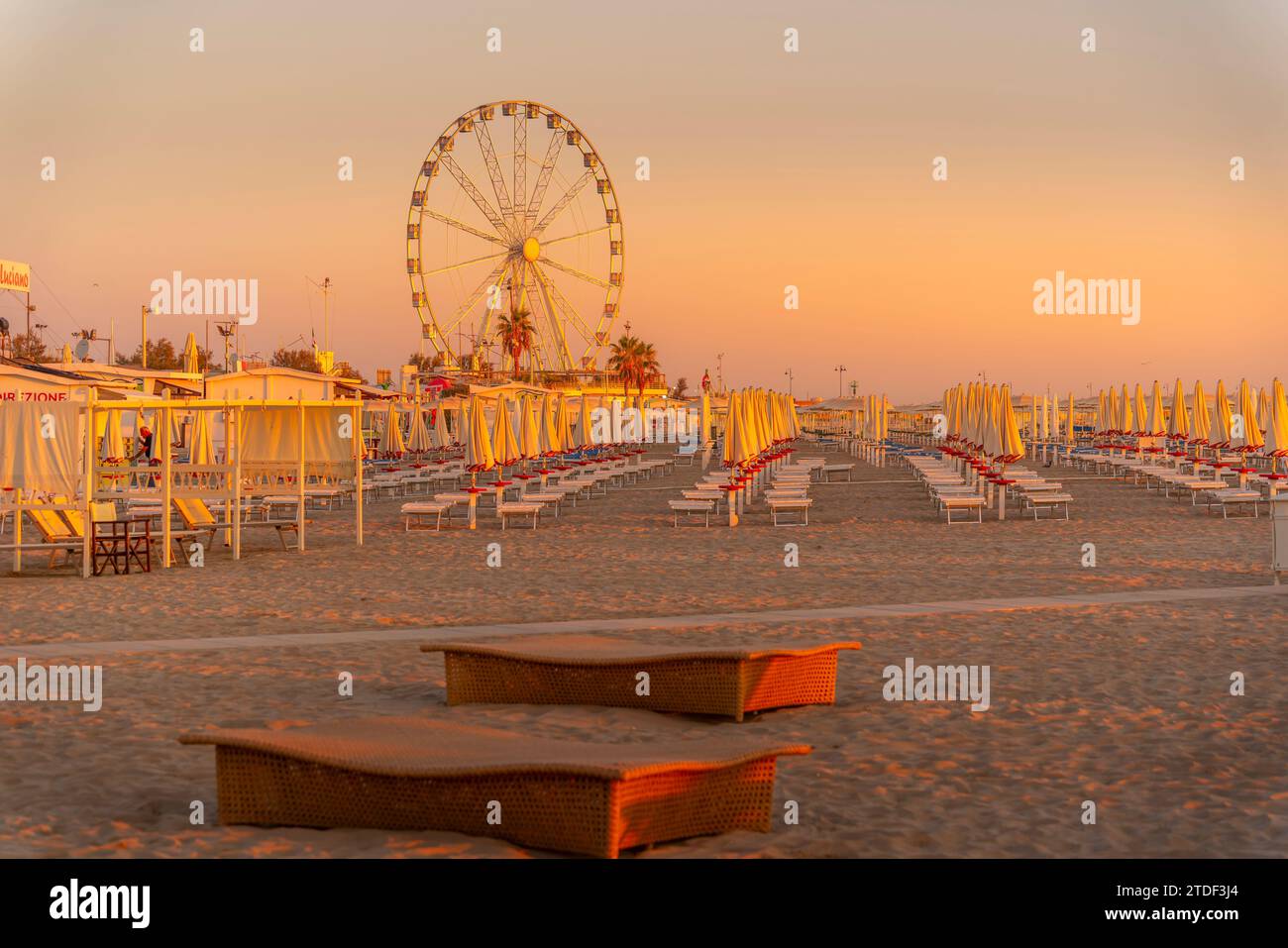 Blick auf Riesenrad und Sonnenschirme am Lido am Strand von Rimini bei Sonnenaufgang, Rimini, Emilia-Romagna, Italien, Europa Stockfoto