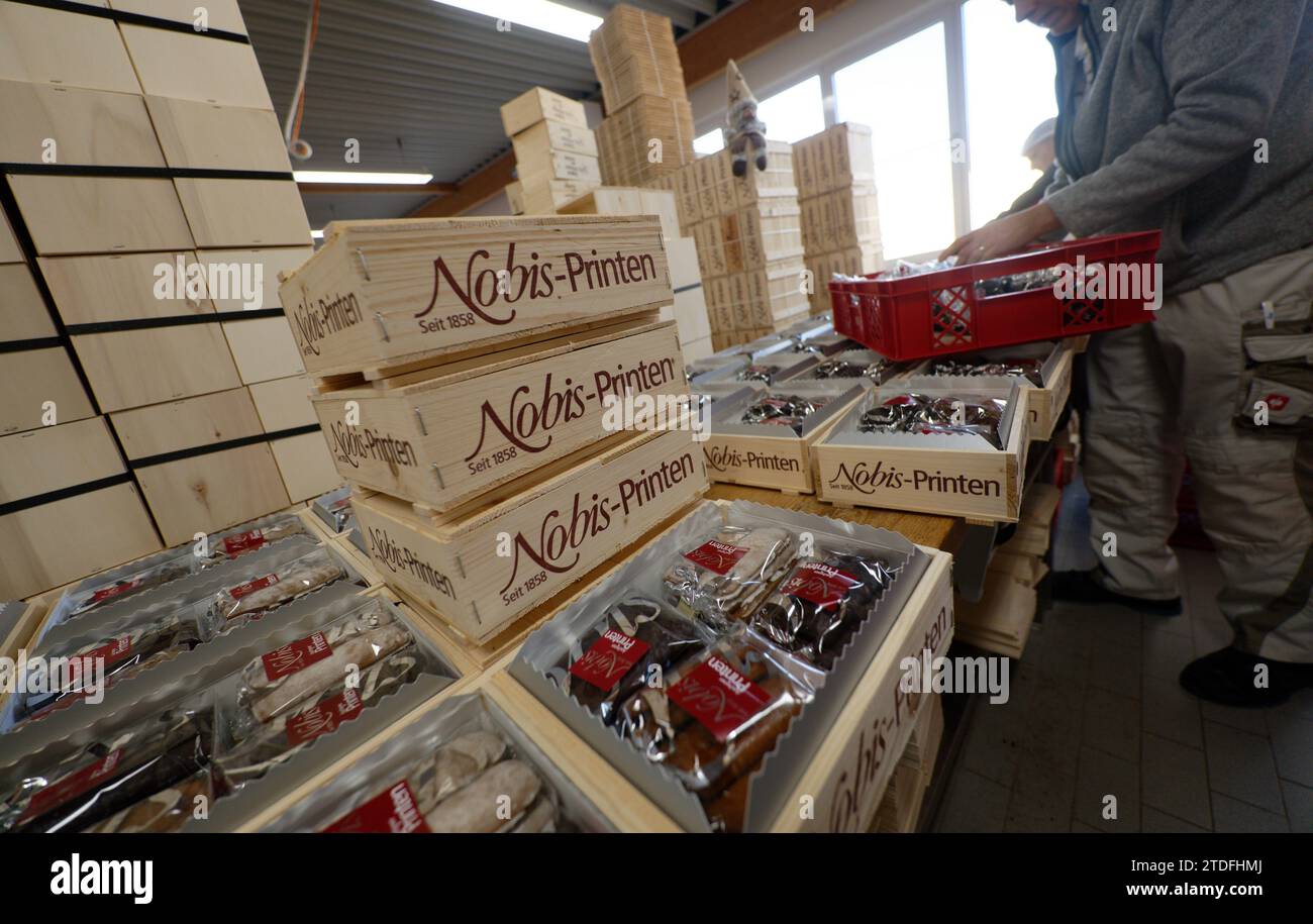 Aachen, Deutschland. Dezember 2023. Ein Mitarbeiter packt Printen in Holzkisten in der Bäckerei Nobis Printen. Quelle: Henning Kaiser/dpa/Alamy Live News Stockfoto