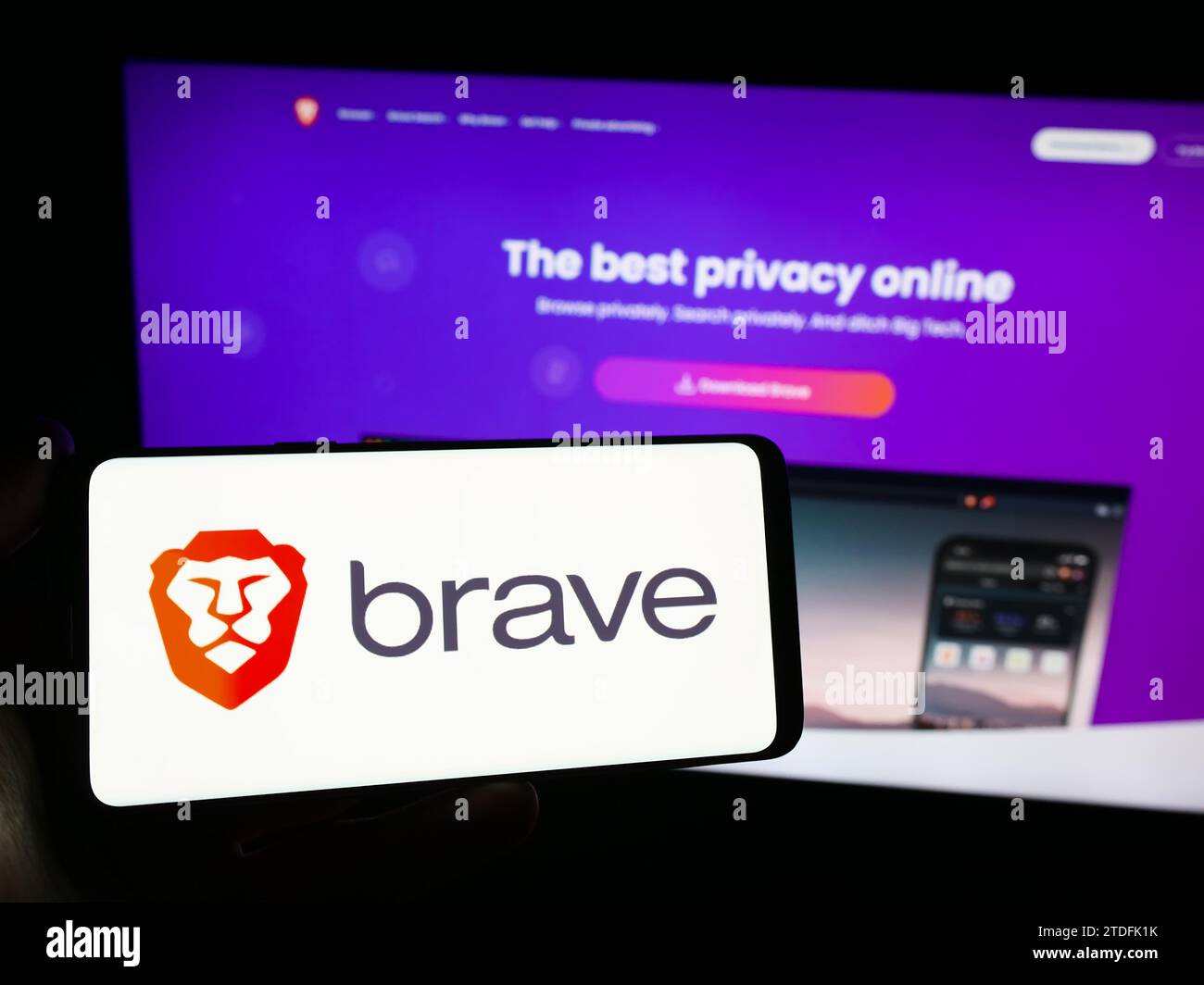 Person mit Smartphone und Logo des US-Webbrowserunternehmens Brave Software Inc. Vor der Website. Schwerpunkt auf dem Display des Telefons. Stockfoto