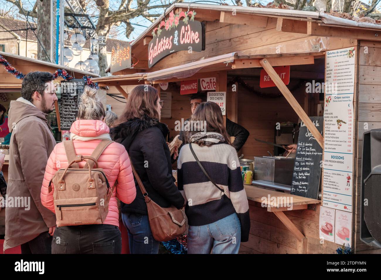 Sarlat-la-Canéda, Nouvelle-Aquitaine, Frankreich - 23. Dezember 2023: Menschen stehen an einem Verkaufsstand, der Galettes und Crepes auf dem Weihnachtsmarkt in Sa verkauft Stockfoto