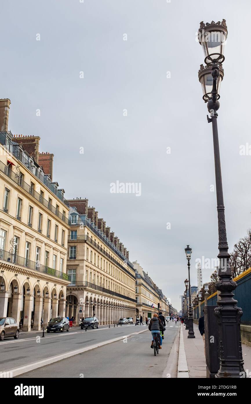 Paris, Frankreich, 2023. Radfahrer, die den Radweg in der Rue de Rivoli genießen, bekannt für seine berühmten Geschäfte, eleganten Cafés und High-End-Hotels (vertikal) Stockfoto