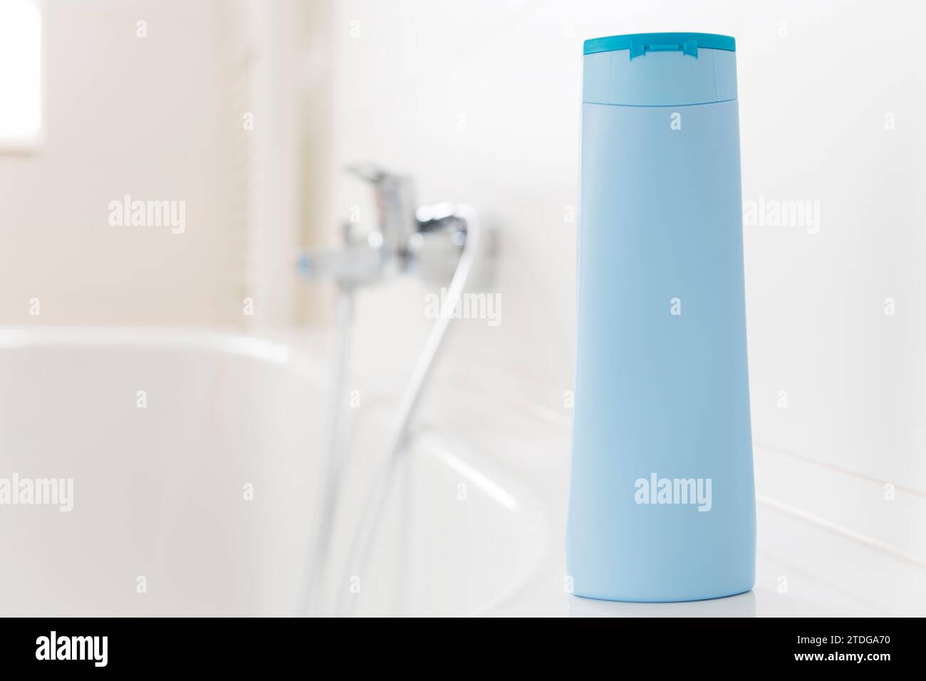 Eine Flasche Shampoo steht auf einer Badewanne in einem hellen Badezimmer - Kopierraum auf der Flasche Stockfoto