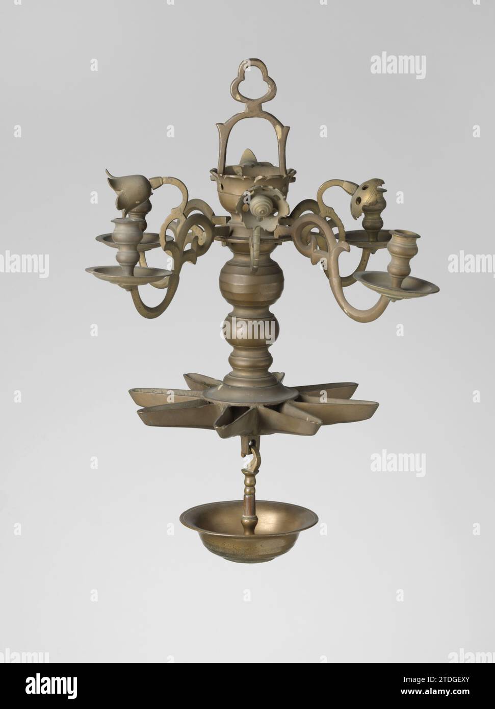 Arm van Sabbath Lampe, unbekannt, 1700 - 1800 Arm von einer Sabbath Lampe. Der S-förmige Arm endet in einer Locke zum Stamm und verwandelt sich nach außen in ein flaches Befestigungsteil, in dem die Glühlampe und die Hohlform am Fuß des profilierten runden Fettfängers angeschraubt werden. Dies ist der zweite Arm, nummeriert mit 2 runden Punkten. Nürnberger Messing (Legierung) Gießarm aus einer Sabbatlampe. Der S-förmige Arm endet in einer Locke zum Stamm und verwandelt sich nach außen in ein flaches Befestigungsteil, in dem die Glühlampe und die Hohlform am Fuß des profilierten runden Fettfängers angeschraubt werden. Das ist der zweite Arm Stockfoto