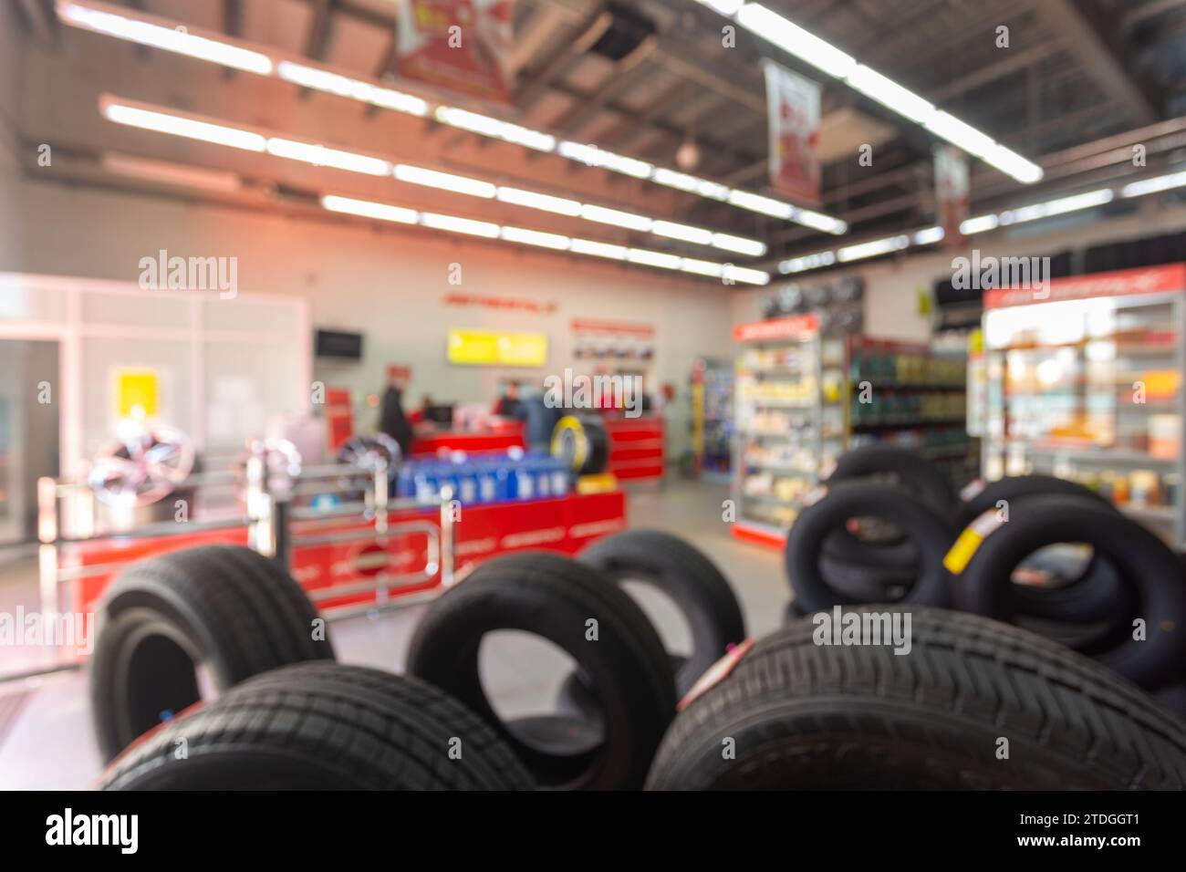 Unscharfe Bildzeilen mit brandneuen Reifen zum Verkauf im Einzelhandel. Defokussierter Hintergrund im Auto- und Reifenhandel. Transportdienste Stockfoto