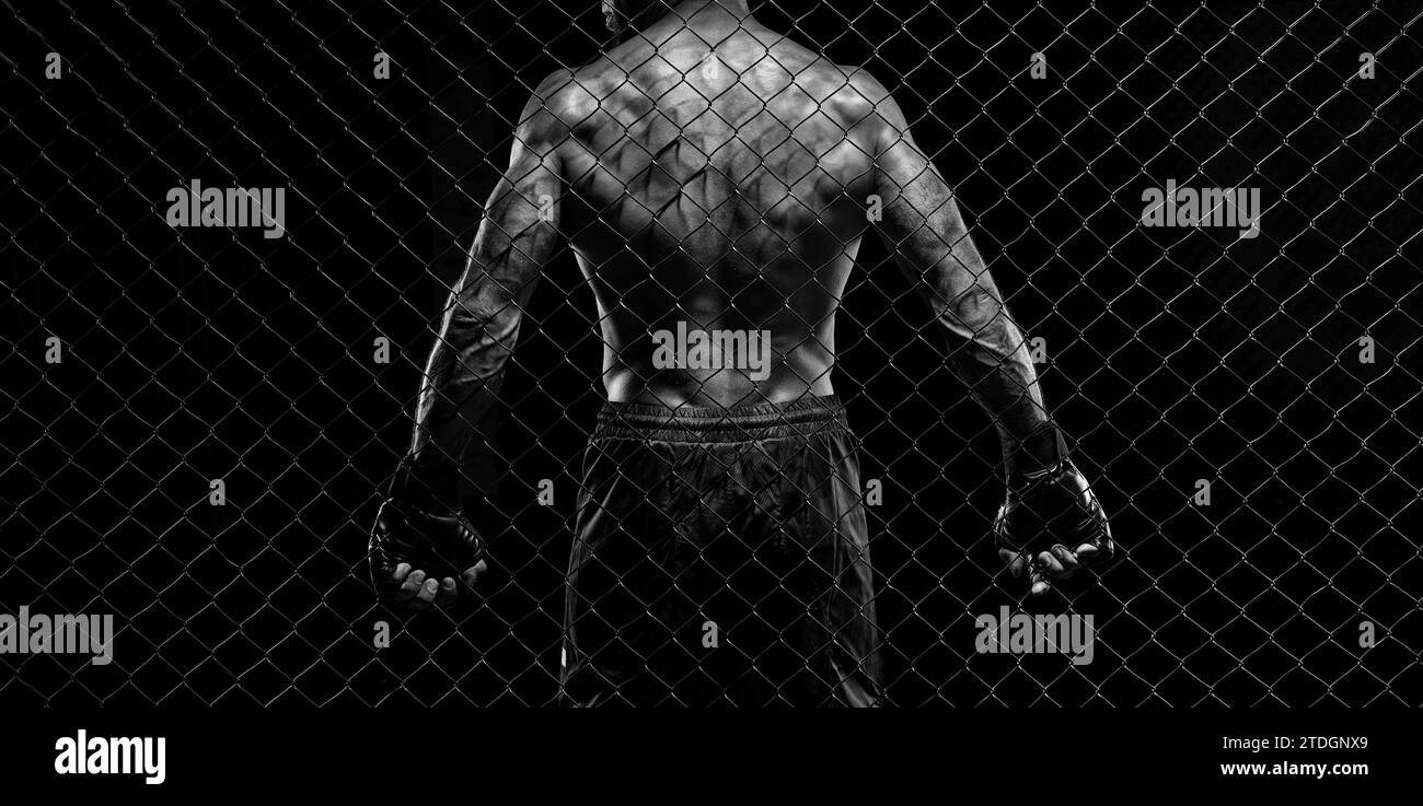 Schwarz-weiß-Bild eines Mannes in einem Boxkäfig. Das Konzept des Sports, Muay Thai, Kampfkunst Stockfoto