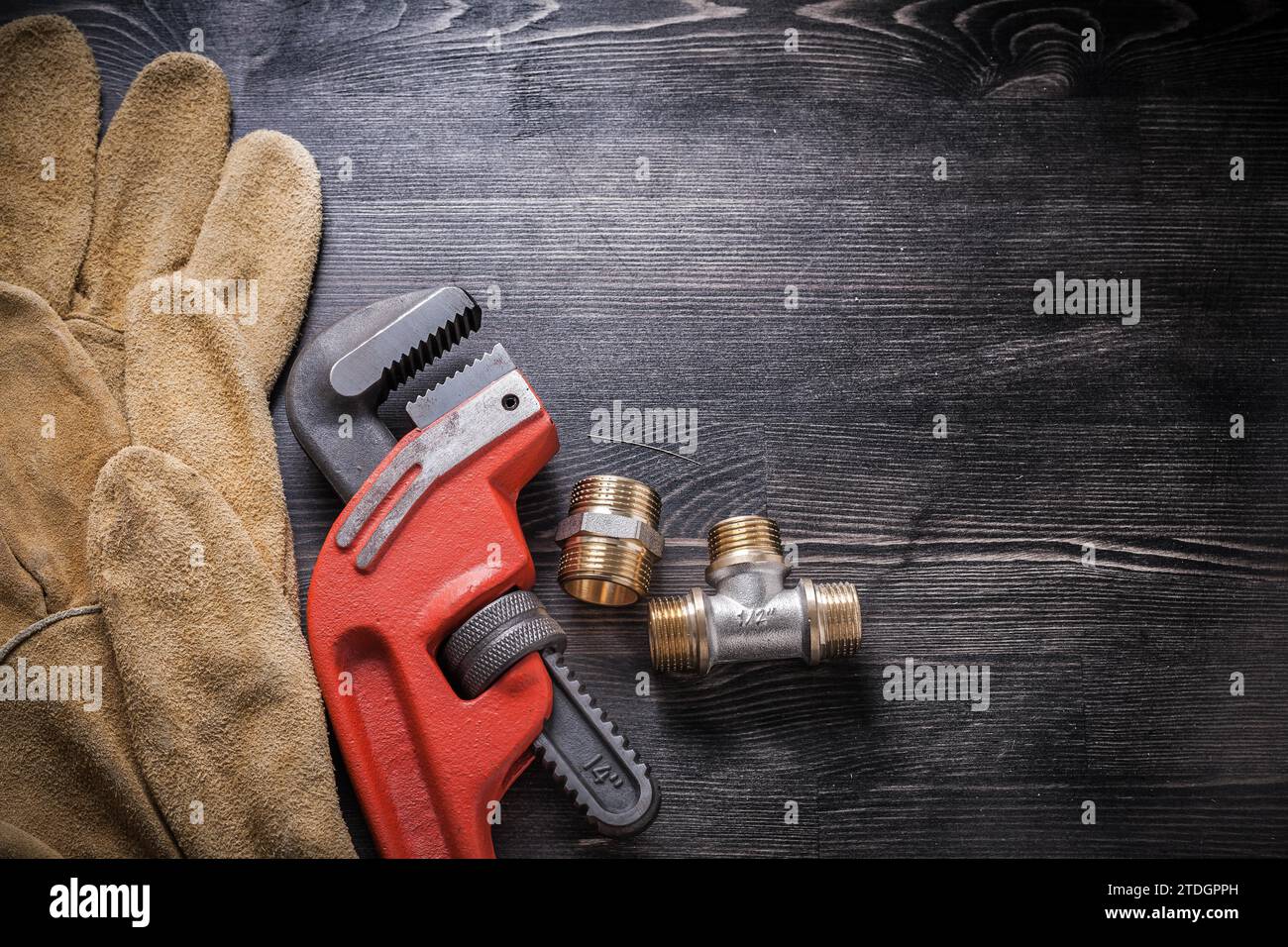 Einstellbare Schraubenschlüssel-Installationen Schutzhandschuhe auf Holzbrett Stockfoto