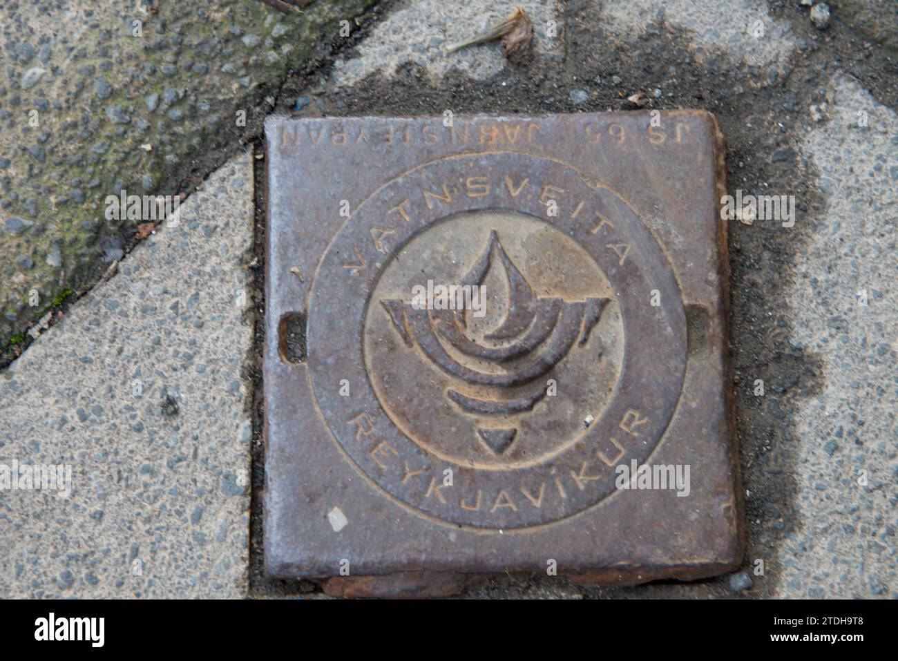 Eine Markierung für den Versorgungsbereich auf einem Bürgersteig in Reykjavik, Island, für den Zugang zum ein- oder Ausschalten von Diensten für ein bestimmtes Gebäude oder Haus. Stockfoto