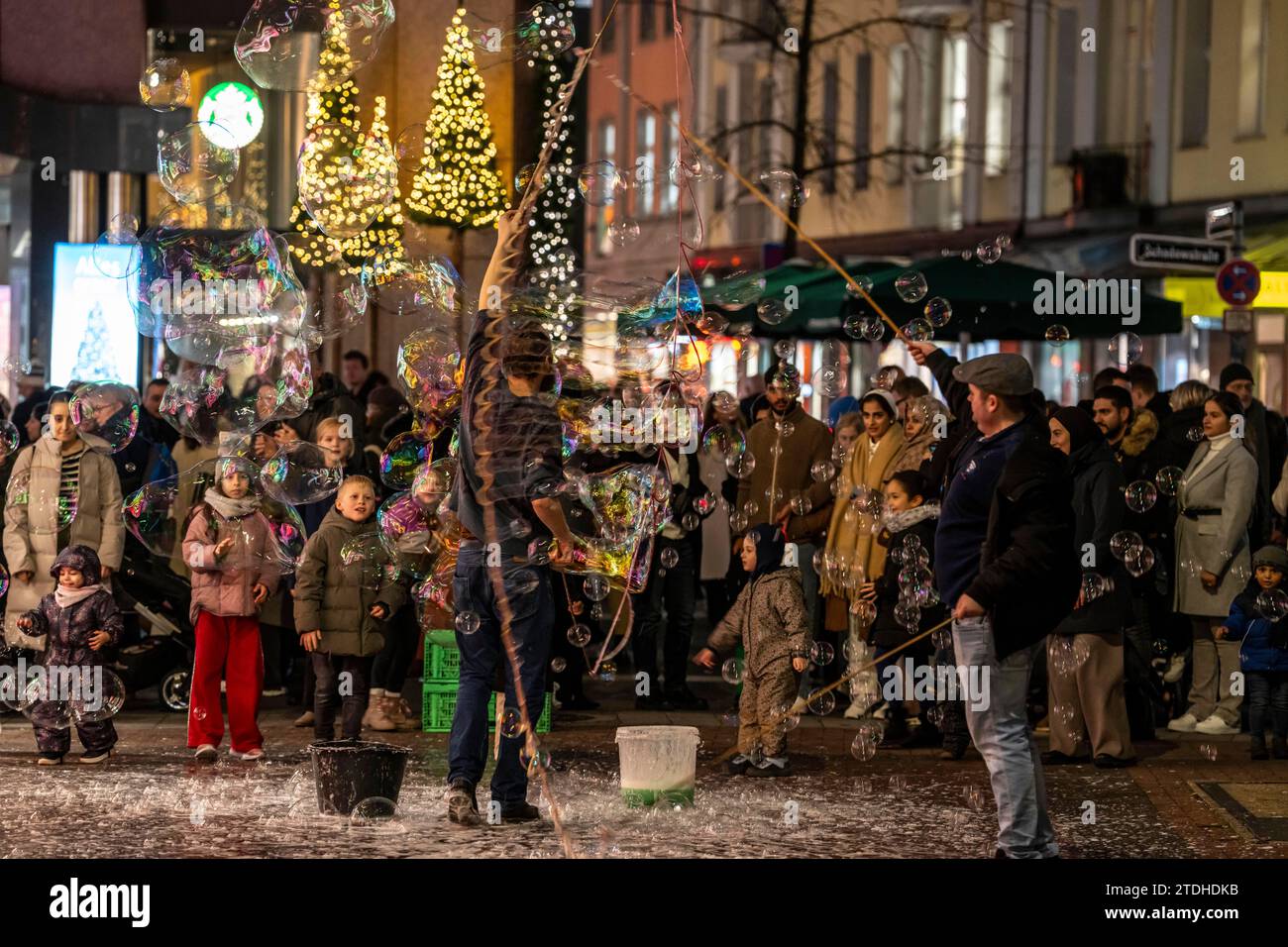 Vorweihnachtszeit, Straßenkünstler, die große Seifenblasen kreieren, in Schadow-Arkaden, im Stadtzentrum von Düsseldorf, NRW, Deutschland, Stockfoto