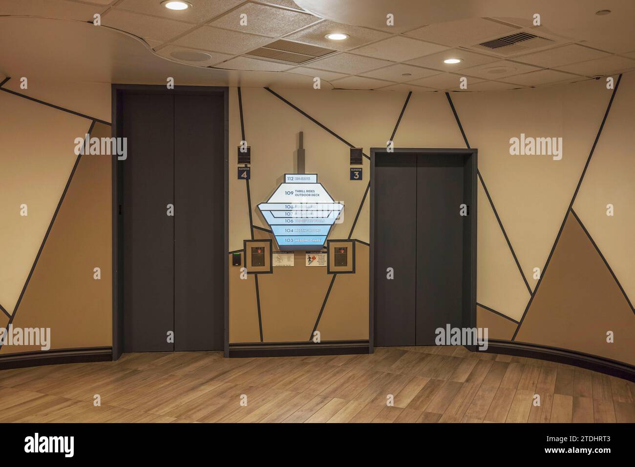 Wunderschöner Innenblick auf das Strat Hotel in braunen Farben, mit Aufzugstüren und einem blauen Himmelsschild als Orientierungshilfe. Las Vegas. Stockfoto