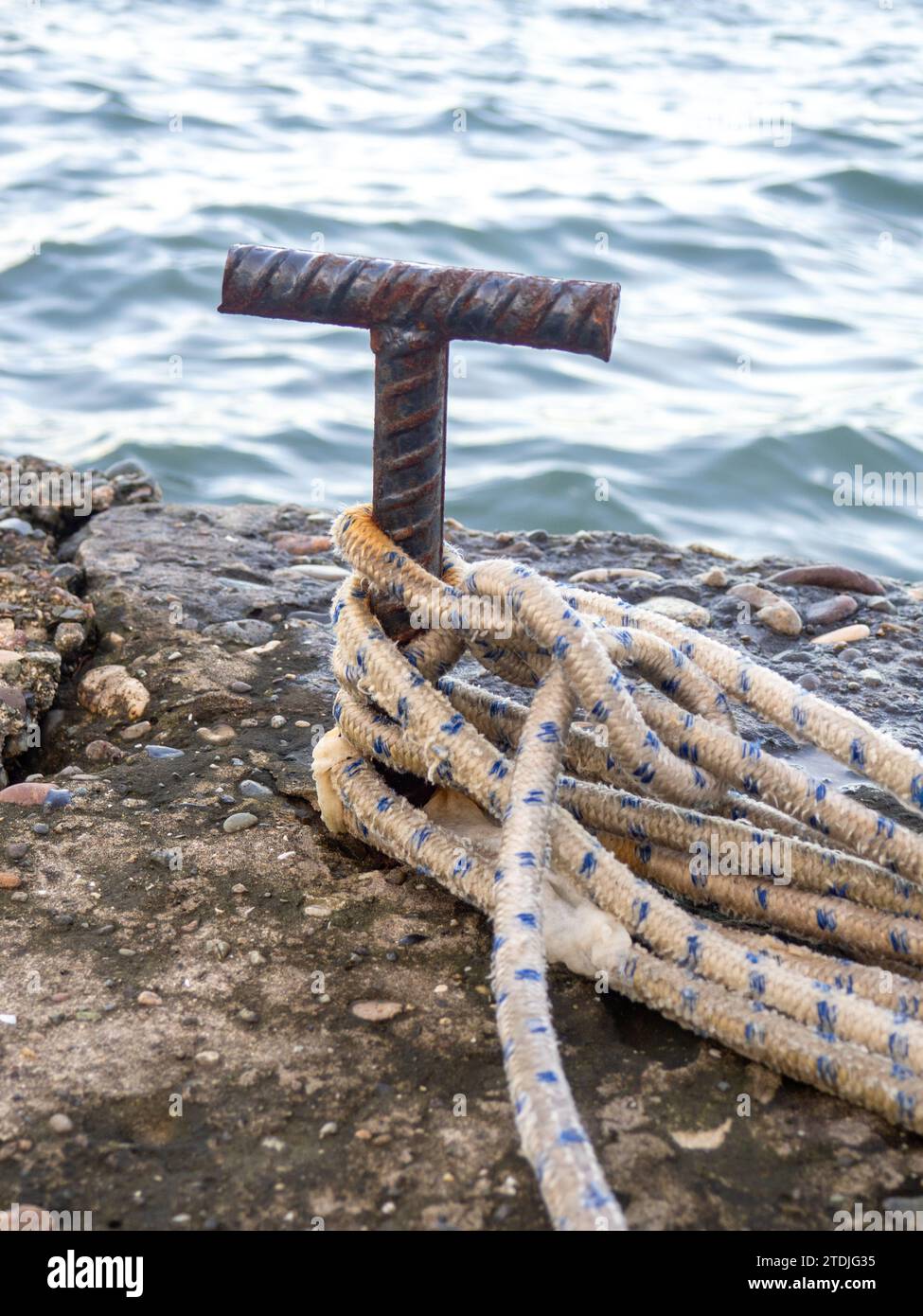 Platz zum Anbringen eines kleinen Bootes. Befestigungen zum Binden der Festmacherleine. Befestigungspunkt. Kleiner Poller auf dem Pier. Segelkonzept für Boote Stockfoto