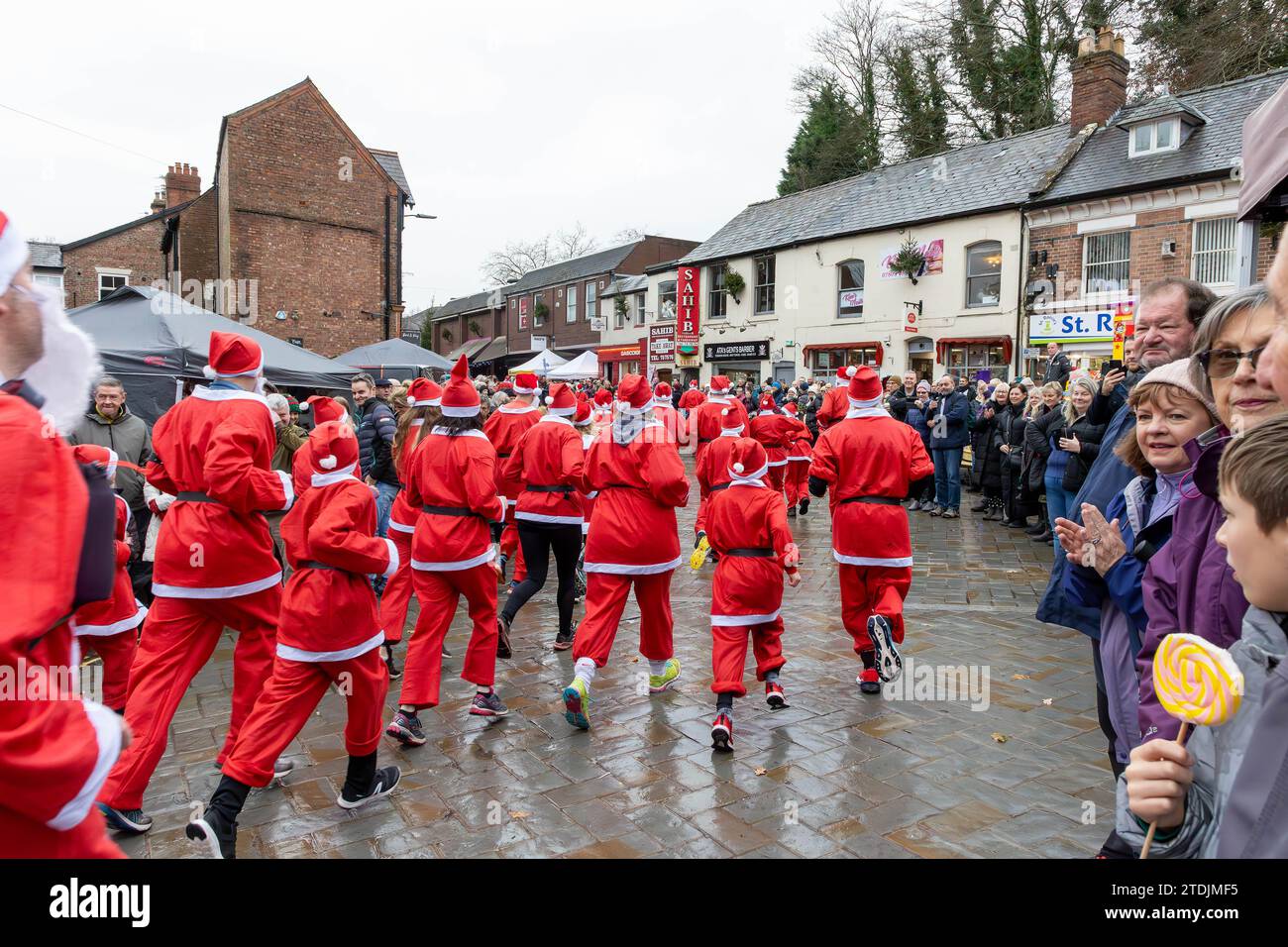 Der Santa Dash von 2023 lief beim Dickensian Day Festival durch das Dorf Lymm in Cheshire Stockfoto