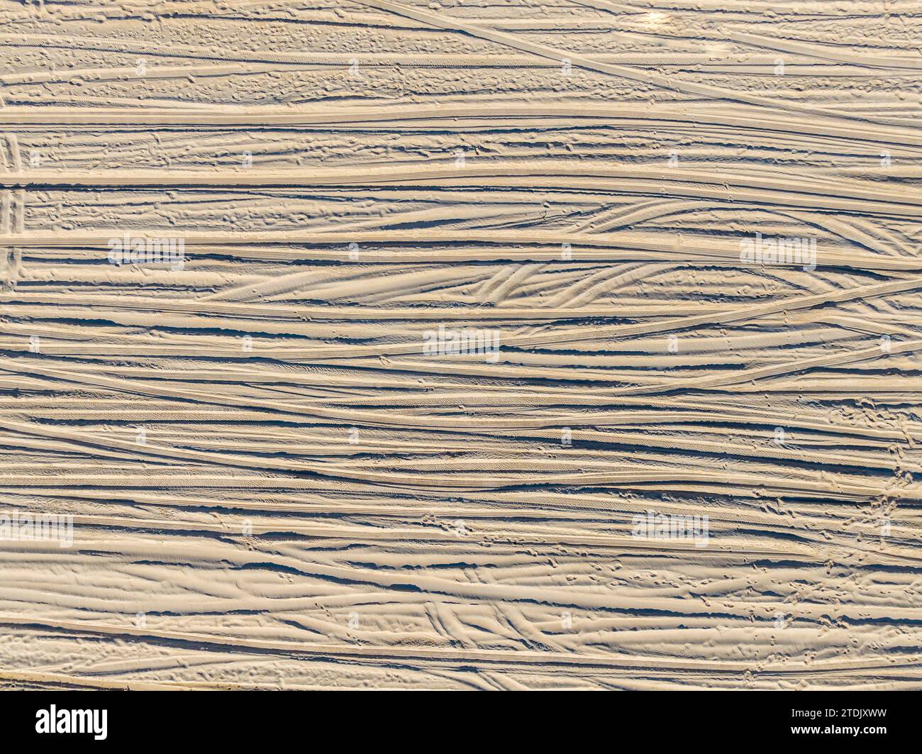 Detaillierte Luftaufnahme der Reifenspuren am Strand Stockfoto