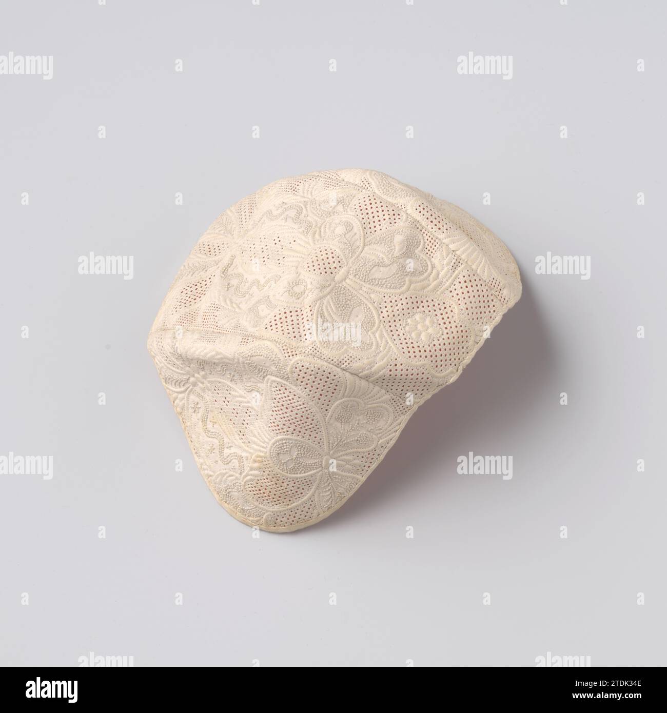 Babymütze, bestehend aus drei Patten, aus genähter Baumwolle (Point de Marseille) mit symmetrischem floralen Phantasiemuster, anonym, ca. 1750 Babymütze, bestehend aus drei Patten, aus genähter Baumwolle (Point de Marseille) mit symmetrischem floralen Phantasiemuster. Modell: Verlängertes Mittelstück mit abgerundeten Teilen auf beiden Seiten. Mit rosa Seide gefüttert. Dekoration: Auf einem feinen Muster aus gestanztem Leinen gearbeitet, das auf der Innenseite entlang der Nähte sichtbar ist. Zusätzlich zum Raster werden Knopf- und Stielstiche auf die Baumwolle aufgebracht. Einige Kanten wurden an einer Erhöhung der Baumwolle für bearbeitet Stockfoto